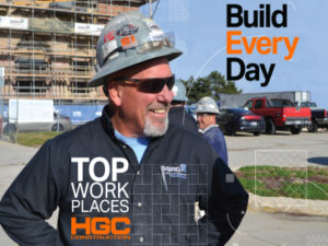 smiling construction worker with Top Work Places and HGC logo