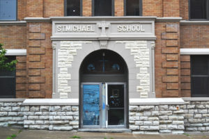 Exterior of school entrance, with stone framing.