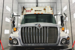 The front of a semi truck. The truck is in the painting bay of the Rumpke Container Maintenance facility.