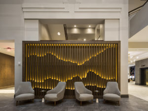 Hotel lobby with four arm chairs and artistic wooden wall display
