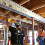 Two crew people reframing Delta Chi house