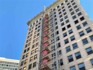 looking up at Ingalls Building under construction with buckhoist